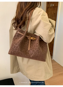 Detailed view of the leopard print tote bag with adjustable leather straps and gold buckle