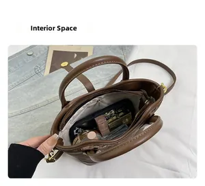 Vue intérieure du sac seau en cuir marron montrant le compartiment et la poche zippée