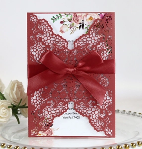 Burgundy laser cut wedding invitation with elegant ribbon bow and floral inner card