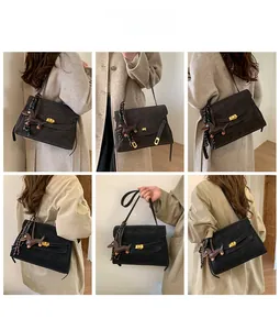 Detail of dark brown flap bag with gold turn-lock and a dachshund dog charm accessory