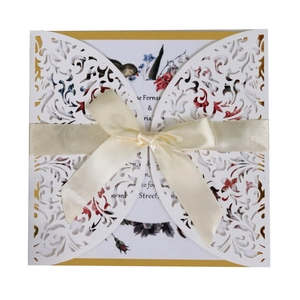 Laser cut wedding invitation with white floral hollow pattern and yellow satin bow