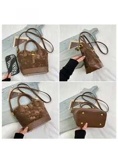 Détails du sac seau marron montrant les angles, coutures et clous de protection dorés