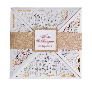 Detailed laser-cut floral wedding invitation with gold glitter band and square name tag