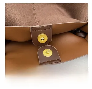 Detail of the high-quality gold magnetic buckle on a dark brown leather tote bag