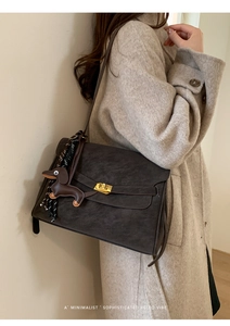 Close-up of retro large leather tote with gold buckle and dachshund pendant detail