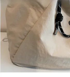 Dettaglio della tela testurizzata beige con cordoncino intrecciato e fibbia in metallo