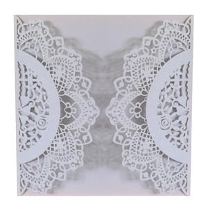 Detailed laser-cut white wedding invitation cover with intricate floral lace patterns