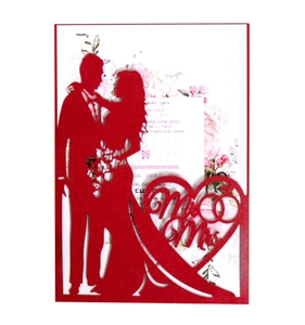 Close-up of laser-cut red wedding invitation with romantic silhouette and Mr & Mrs art