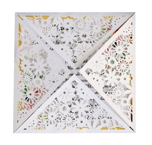 Macro view of white laser-cut floral lace invitation with gold accents and floral card