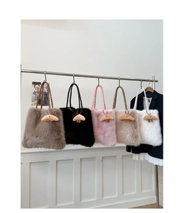 Plush tote bags in five colors with woven handles and cute croissant charms shown on a rack
