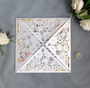 Macro view of laser-cut floral pattern on pearlescent paper wedding invitation