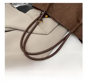 Detail of comfortable shoulder straps on a vintage brown suede tote bag with wooden beads