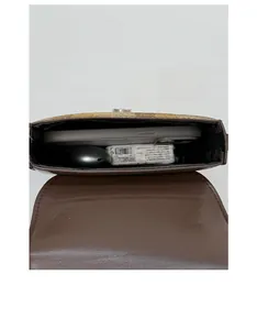 Internal view of brown plaid mini saddle bag showing phone and earphone storage space