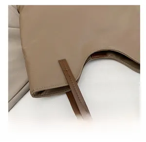Detail showing high-quality stitching on khaki fabric with brown leather strap joint