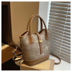Détail du sac taupe texturé avec garniture marron foncé et boucle dorée chic