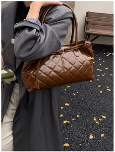 Sac cabas matelassé marron avec motif à losanges porté par un mannequin en scène automnale