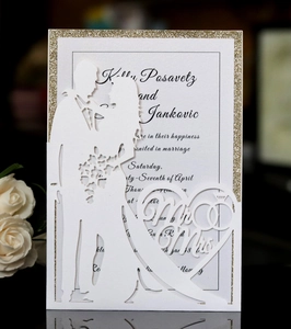 Detailed laser-cut wedding invitation featuring Mr & Mrs silhouettes and gold glitter border