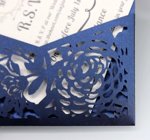 Intricate laser-cut rose details on navy blue pearlescent wedding invitation cover