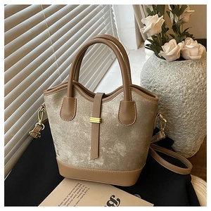 Vue détaillée du sac seau métallique champagne avec finitions en cuir marron et boucles