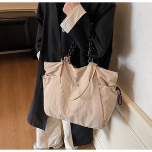 Dettaglio della borsa tote in tela beige con manici intrecciati e coulisse laterale