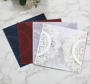 Detail of laser-cut lace patterns on wedding invitation envelopes in four elegant colors