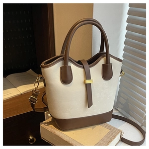 Détail du sac seau rétro beige et marron avec boucle dorée et texture en cuir mat