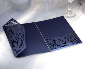 Detailed laser-cut navy blue wedding invitation with intricate floral hollow rose pattern