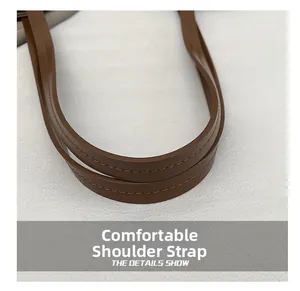 Detailed close-up of durable brown leather shoulder straps with reinforced stitching