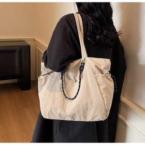 Dettaglio della coulisse laterale e della chiusura magnetica sulla grande borsa beige