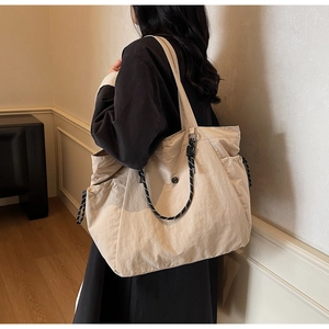 Dettaglio del cordoncino laterale su questa grande borsa tote beige in tela da donna