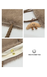 Detail of brown faux fur tote with woven strap, magnetic closure and plush charm