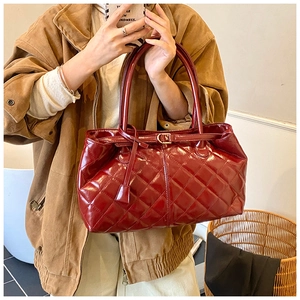 Détail d'un grand sac cabas matelassé rouge bordeaux avec finition brillante chic