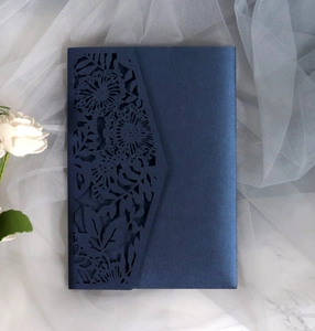 Detail of navy blue pearlescent laser-cut lace invitation card with floral textures