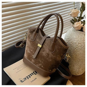 Détail du sac seau marron vintage en daim mat et cuir avec boucle en métal doré