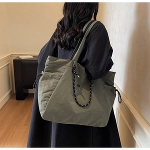 Vista posteriore della grande borsa tote verde oliva con dettaglio in corda intrecciata