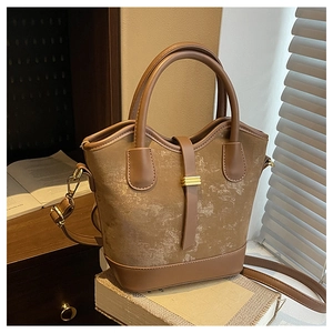 Gros plan d'un sac seau vintage marron en cuir texturé avec une boucle dorée élégante