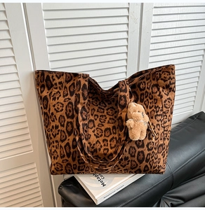 Close-up of leopard print tote bag fabric with cute brown plush bear charm detail