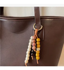 Détail du sac cabas en toile avec garniture en cuir et perles de bois colorées ethniques
