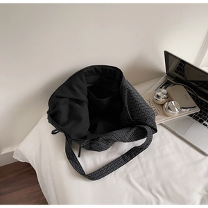 Detail of the black and white checkered canvas tote bag interior with open inner pocket