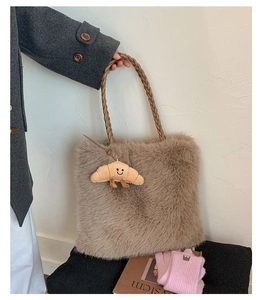 Close-up of fluffy faux fur tote bag with braided rope handle and croissant charm