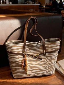 Large zebra pattern canvas tote bag with brown leather handles and bead tassel