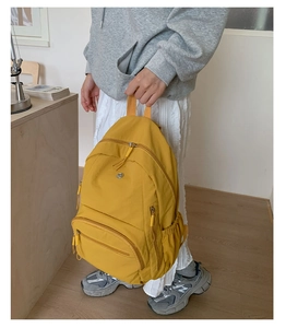 Nahaufnahme gelber Nylon-Rucksack mit mehrlagigen Reißverschlüssen und Seitentaschen