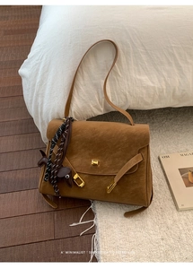 Detail of vintage brown suede tote bag with dog charm and gold square metal buckle