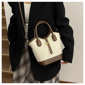Détail du sac seau bicolore beige et marron vintage avec boucle dorée et poignée