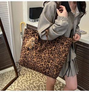 Close-up of leopard print tote bag featuring velvet texture and brown plush bear charm
