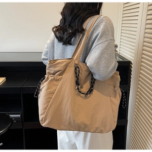 Dettaglio della borsa tote in tela kaki con coulisse regolabile laterale e grande capacità