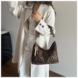 Detail der Hobo-Tasche mit Leopardenmuster, Boho-Perlenanhänger und Lederriemen