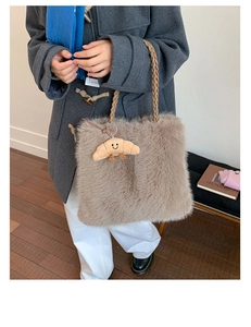 Detailed shot of a beige faux rabbit fur tote bag with a woven rope handle and plush charm