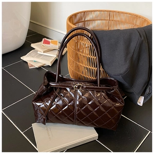 Gros plan d'un sac cabas matelassé marron foncé avec une finition brillante raffinée
