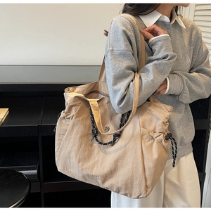 Dettaglio della borsa tote in tela kaki capiente con cordoncino intrecciato e pieghe